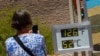 Una mujer toma una fotografía de un termostato que marca 52 grados Celsius y 126 grados Fahrenheit el 7 de julio de 2024, en el Parque Nacional del Valle de la Muerte, California, EEUU. 