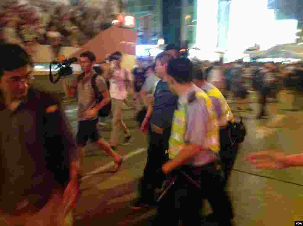 被指控歐打示威者的反佔中人士被聲援學生市民包圍並被警方護送離開現場(美國之音海彥拍攝)