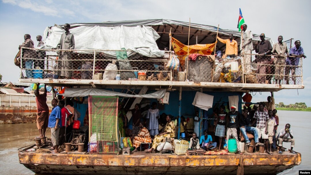 Southern Sudanese people arrive in a barge at the port in Juba, August 31, 2012. 