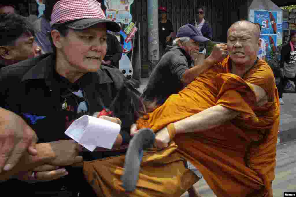 Para anggota kelompok "Kaus Merah" yang pro-pemerintah menyerang seorang pendeta Buddha di pinggiran ibukota Bangkok Thailand.