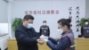 中國國家主席習近平戴著口罩視察北京安華里小區時一名防疫人員檢測他的體溫。（2020年2月10日）