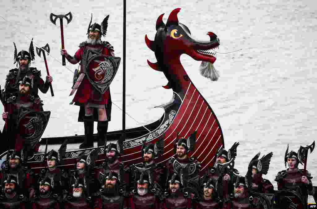 Members of the Up Helly Aa 'Jarl Squad' pose for photographs with their Viking galley ship in Lerwick, Shetland Islands, Britian.