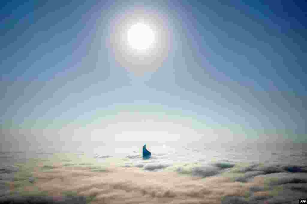 This aerial view shows the top of al-Hamra tower through heavy fog obscuring the rest of the skyline of Kuwait City.