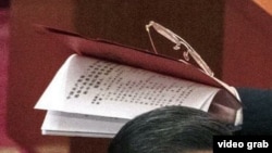 視頻截圖顯示，習近平叫來的工作人員手裡拿著那份不許胡錦濤在中共20大會場翻閱的人事名單。