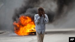Un hombre pasa junto a una barricada en llamas durante una protesta por la muerte del periodista Romelo Vilsaint, en Puerto Príncipe, Haití, el 30 de octubre de 2022. La violencia arrasa la isla, los periodistas del país son atacados y muchos se ven obligados a exiliarse.