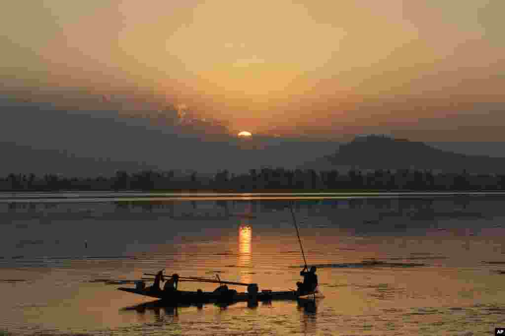 Seorang nelayan Kashmir memancing ikan saat matahari terbenam di danau Dal, kota Srinagar, Kashmir-India.