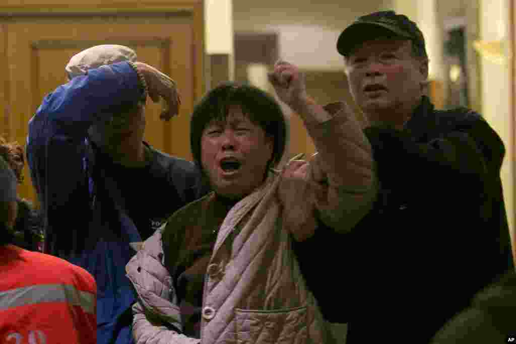 Keluarga penumpang pesawat Malaysia Airlines MH370 berteriak histeris di Beijing, China, setelah pengumuman resmi bahwa pesawat MH370 telah terjatuh di Samudera India.