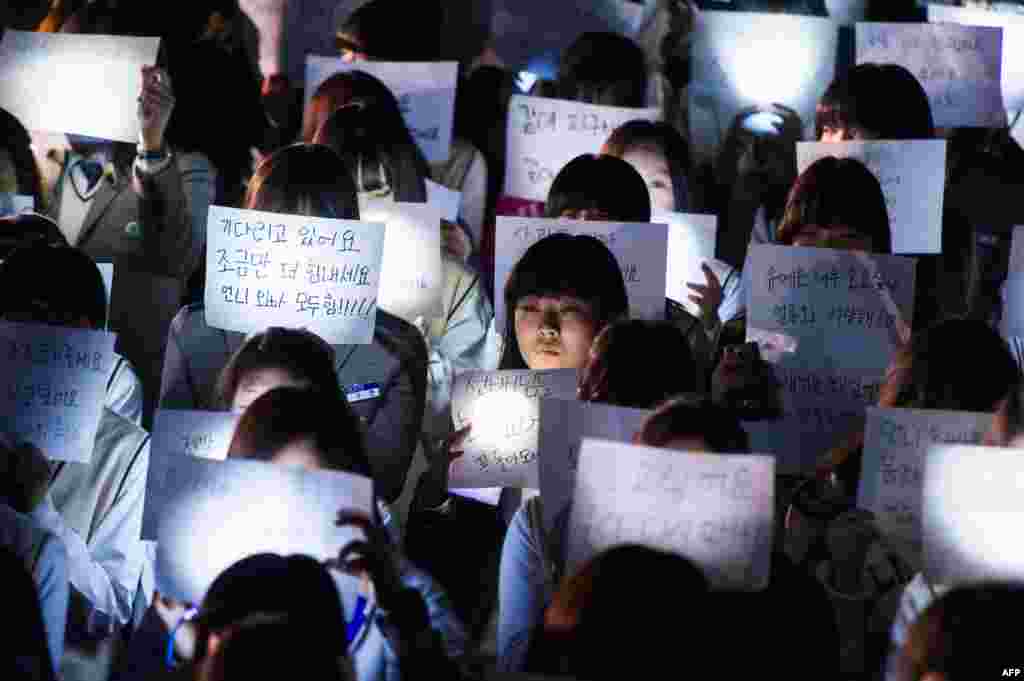 Murid-murid di SMU Danwon di Ansan memegang pesan-pesan untuk murid-murid yang menjadi korban dalam feri yang terbalik di tengah laut di Korea Selatan. 