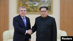 31일 조선중앙통신이 공개한 사진에서 김정은(오른쪽) 북한 국무위원장과 토마스 바흐 국제올림픽위원회(IOC) 위원장이 악수하고 있다. 