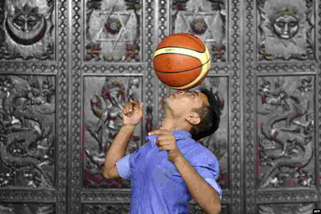 Thaneswar Guragai makes an attempt to break a Guinness World Record by keeping a basketball spinning on his nose for seven seconds, in Kathmandu, Nepal.
