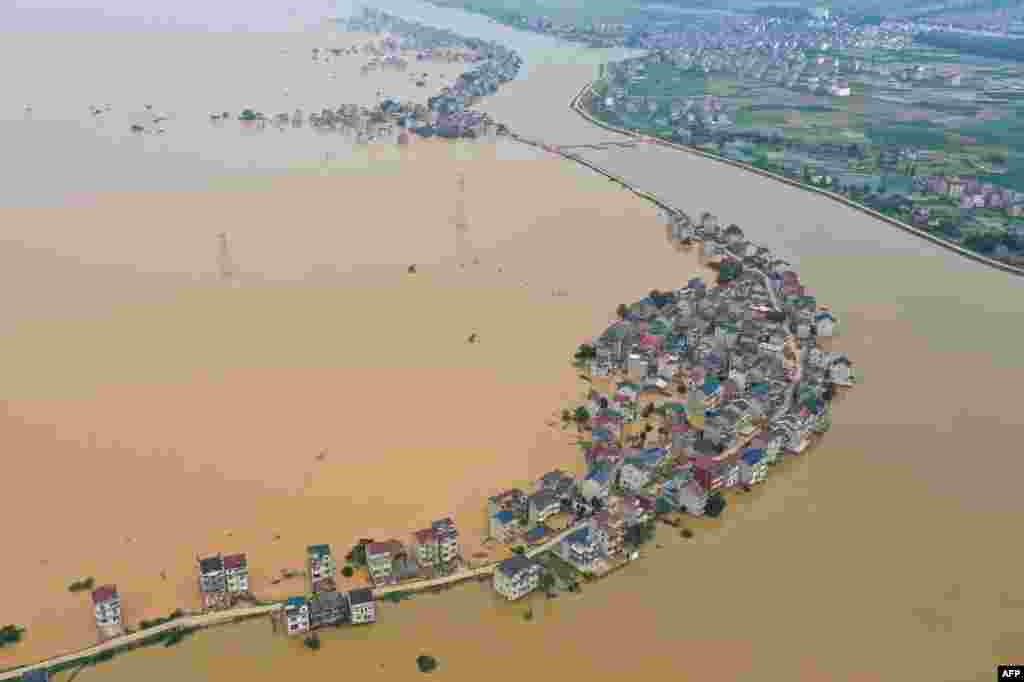 This aerial view shows submerged streets and inundated buildings after a dam was breached due to flooding in Jiujiang in China's central Jiangxi province.