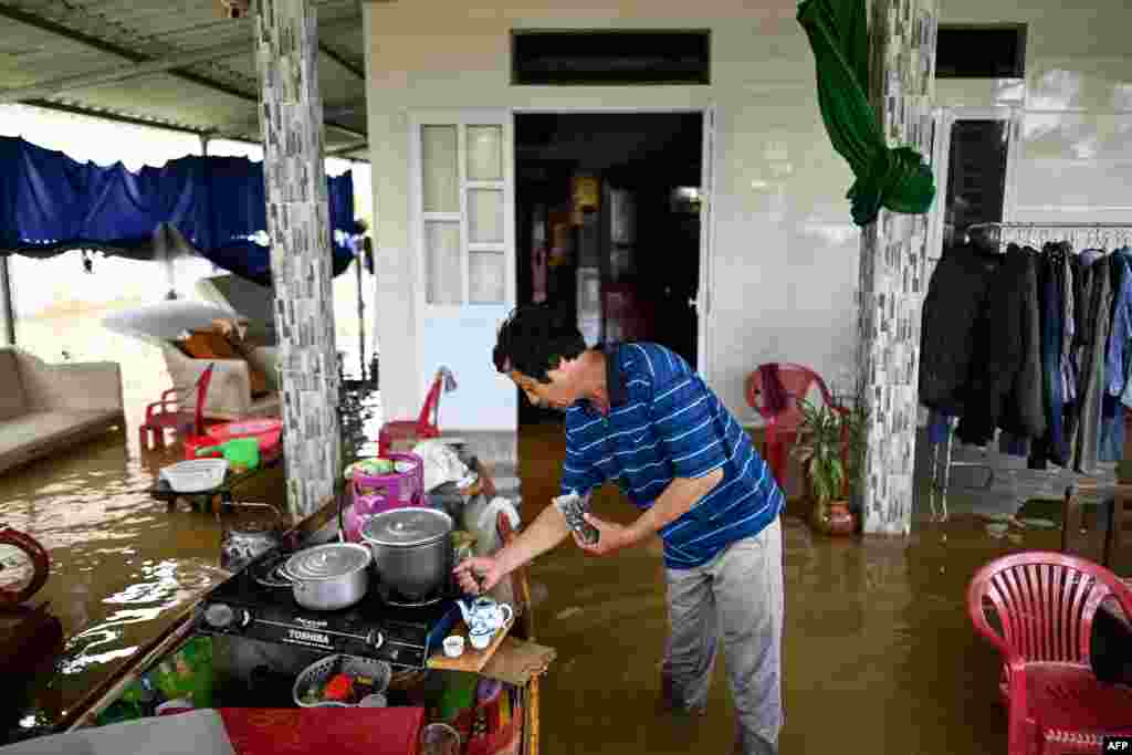 Phan Gia Quang makes tea at his flooded house in Quang Dien district in central Vietnam's Hue province.