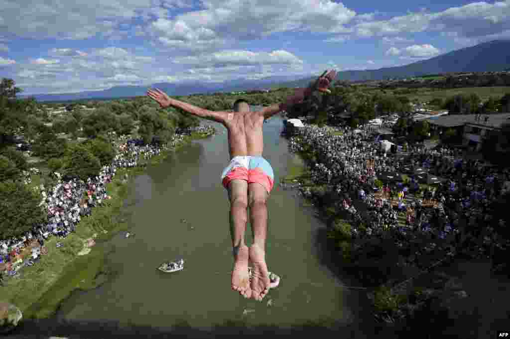 A diver jumps from the 22-meter-high bridge "Ura e Shenjte" near the town of Gjakova, Kosovo, as a sign of protest after police canceled the 70th traditional annual High Diving competition at the bridge due to spectators failing to keep social distancing rules.