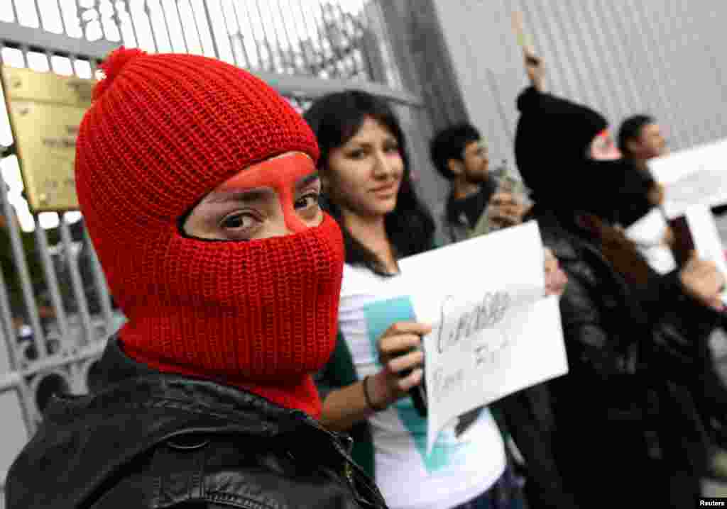Protesters wear masks outside the Russian Embassy in Mexico.