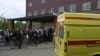 People gather outside a hospital, where Russian opposition leader Alexei Navalny receives medical treatment in Omsk, Russia August 21, 2020.