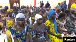 FILE - A still image taken from video shows a group of girls, released by Boko Haram jihadists after kidnapping them in 2014 in the north Nigerian town of Chibok, sitting in a hall as they are welcomed by officials in Abuja, Nigeria, May 7, 2017. 