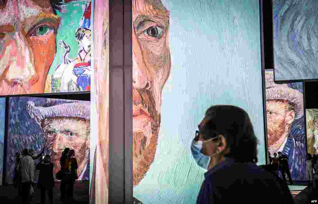Members of the media wearing face masks look at an exhibition titled ‘Van Gogh Alive’ during a media preview at the Royal Hall of Industries in Sydney, Australia.