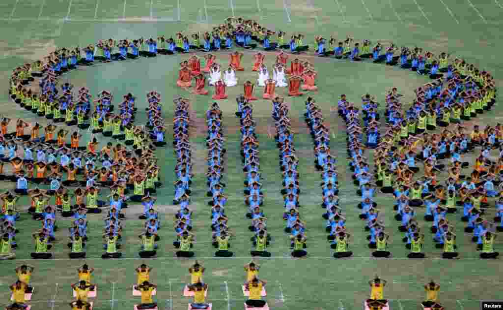 Para siswa melakukan yoga dalam gladi resik menjelang perayaan 'Hari Yoga sedunia' di Ahmedabad, India.