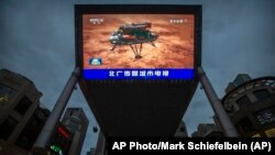 北京街頭一家商場的大屏幕正在播放中國官媒報導中國火星探測器天問一號成功登陸火星的視頻。 （2021年5月15日） 