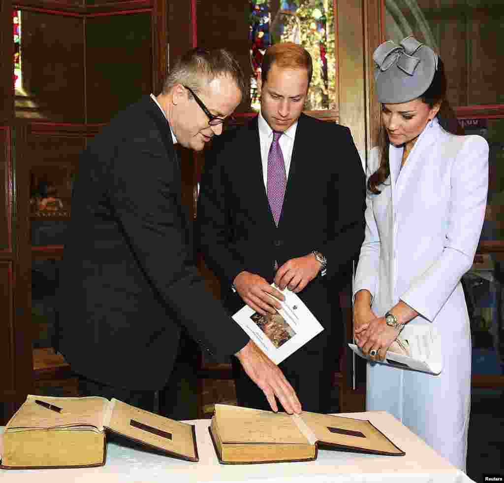 Pangeran William dari Inggris dan istrinya Catherine, Duchess of Cambridge, bersiap menandatangani alkitab dan buku doa kuno menyusul kebaktian Paskah di Katedral St. Andrews di Sydney. (Reuters/Lisa Maree Williams)