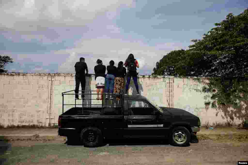 A family watches the funeral of a relative at La Bermeja cemetery in San Salvador, El Salvador, under the coronavirus disease (COVID-19) protocols, as the outbreak continues, July 27, 2020.