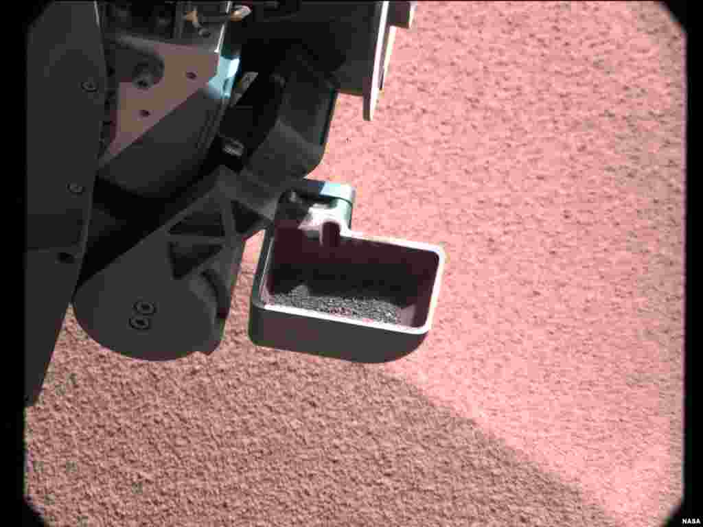 The scoop on NASA's Curiosity rover shows the larger soil particles that were too big to filter through a sample-processing sieve that is porous only to particles less than 150 microns across, October 10, 2012.
