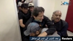 Waziri Mkuu wa zamani wa Pakistani Imran Khan akisaidiwa baada ya kupigwa risasi mguunin huko Wazirabad, Pakistani Novemba 3, 2022. (REUTERS)