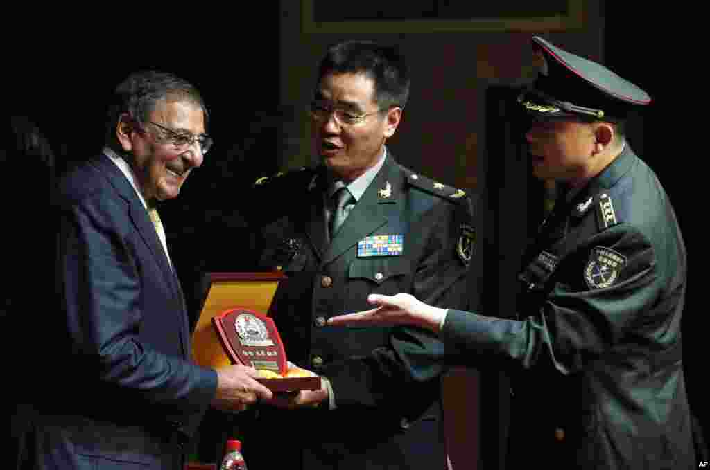 U.S. Defense Secretary Leon Panetta, left, receives a plaque after he addresses cadets at the PLA Engineering Academy of Armored Forces in Beijing, China, September 19, 2012.