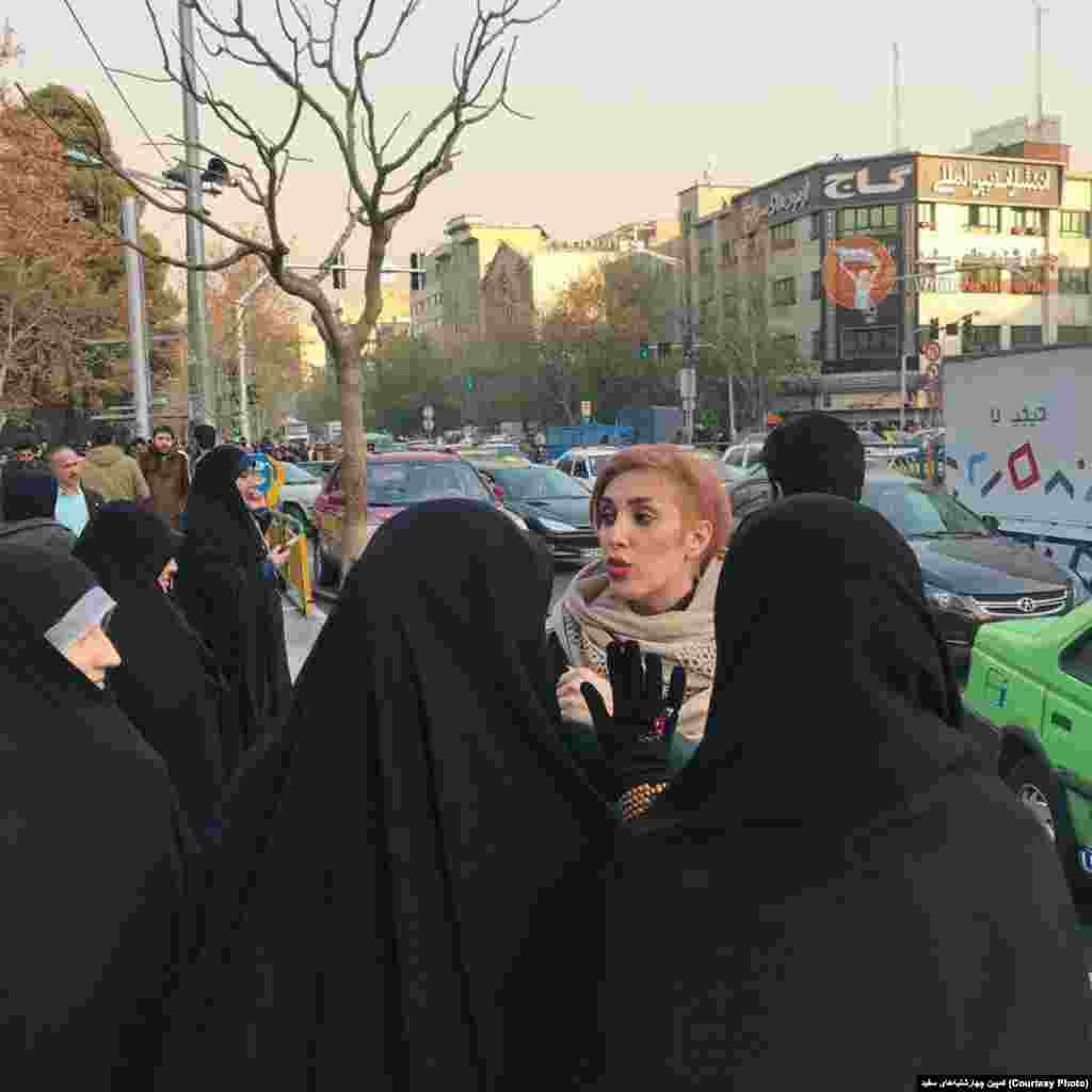 اعتراض به حجاب تهران - صفحه کمپین چهارشنبه‌های سفید در شرح این عکس نوشت:‌حتی وقتی دورم جمع میشن و با لحن تند بازخواستم میکنند ؛ کاملا مسالمت امیز از حق ازادیِ حجابِ سلب شده ام دفاع می‌کنم.