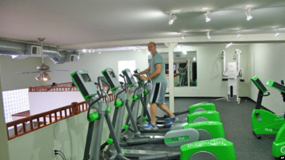 Green Microgym owner Adam Boesel on an elliptical machine that generates electricity during a workout.