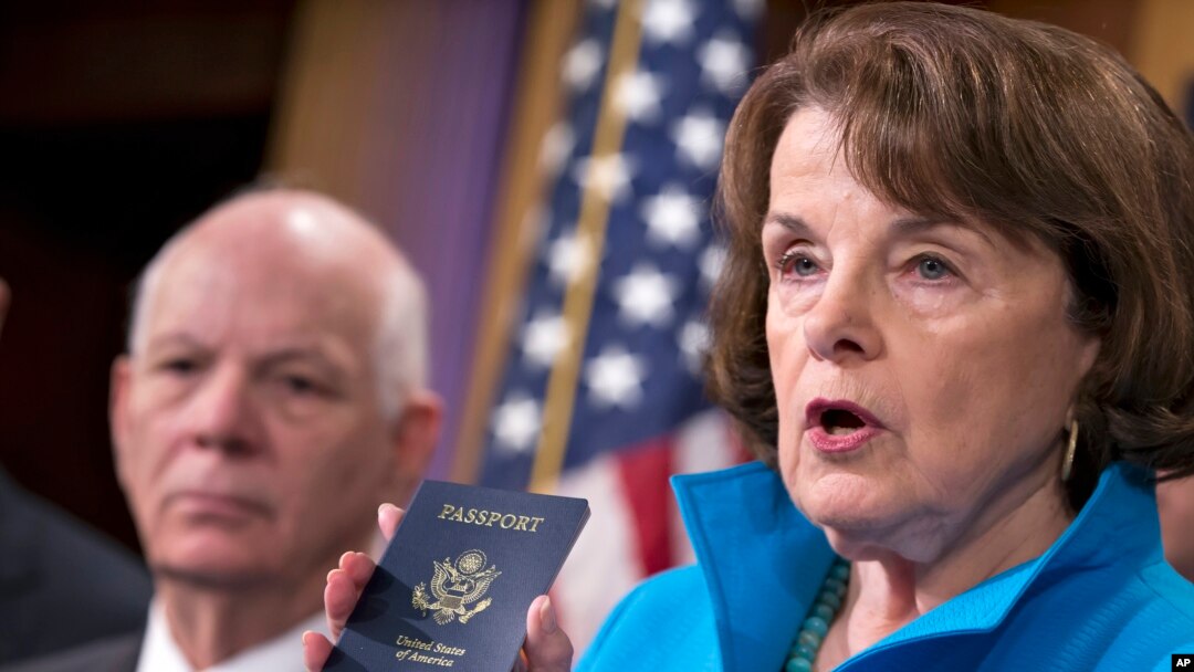 Senate Intelligence Committee Vice Chair Sen. Dianne Feinstein (r) joined by Sen. Ben Cardin, left, points to the embedded chip in her passport that contains digital information, as she and other Democrats talk about security measures for Syrian refugees and others coming into the U.S., Nov. 19, 2015, during a news conference on Capitol Hill in Washington.