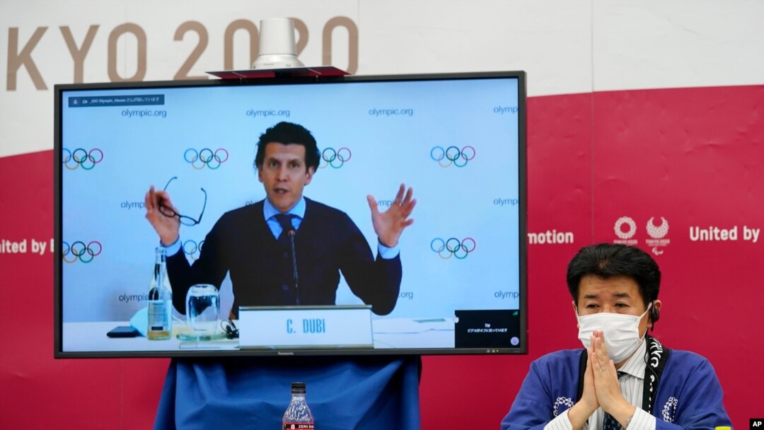 크리스토프 뒤비 국제올림픽위원회(IOC) 집행국장이 9일 화상 기자회견을 했다. 도쿄올림픽 관계자들이 일본 도쿄에서 회견을 지켜보고 있다.