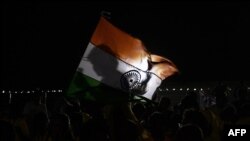 A spectator holds an Indian flag after a mission of Indian Space Research Organization's Chandrayaan-2, with the Geosynchronous Satellite Launch Vehicle on board was called back because of a technical snag in Sriharikota, India, July 15, 2019.