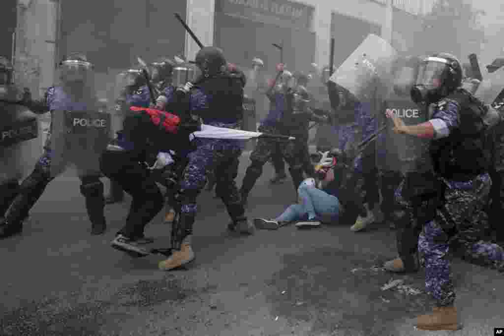 Riot policemen beat anti-government protesters during a protest near Parliament Square, in Beirut, Lebanon.