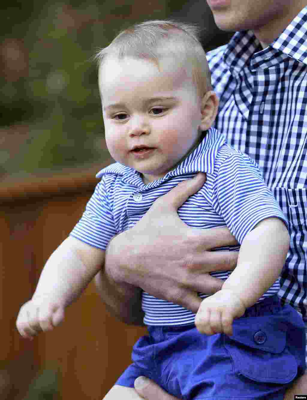 Pangeran William dari Inggris menggendong puteranya, George ketika melakukan kunjungan ke kebun binatang Taronga di Sydney, Australia. 
