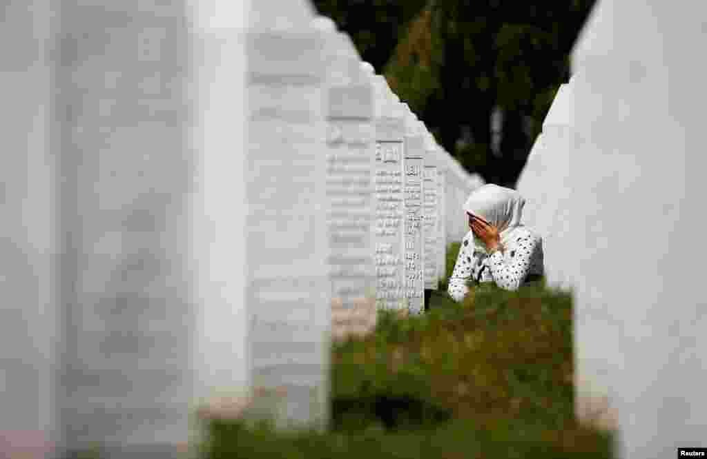A woman cries at a graveyard, ahead of a mass funeral in Potocari near Srebrenica, Bosnia and Herzegovina, July 11, 2020. Bosnia marks the 25th anniversary of the massacre of more than 8,000 Bosnian Muslim men and boys, with many relatives unable to attend due to the COVID-19 outbreak. 