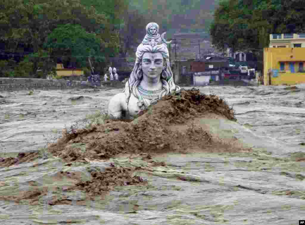 A submerged idol of Hindu Lord Shiva stands in the flooded River Ganges in Rishikesh, in the northern Indian state of Uttarakhand, June 18, 2013.