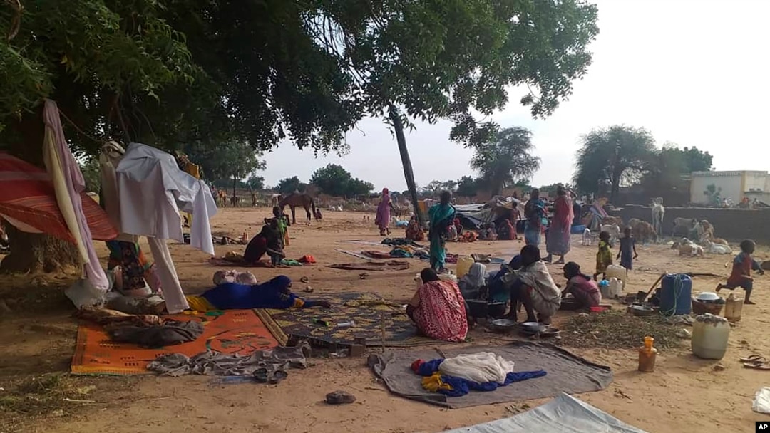 FILE - Residents displaced from a surge of violent attacks squat on blankets and in hastily made tents in the village of Masteri in west Darfur, Sudan, July 30, 2020. 