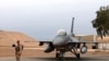 FILE - An Iraqi army soldier stands guard near a U.S.- made Iraqi air force F-16 jet at Balad Air Base, Iraq, Feb. 13, 2018 . Three rockets fired by militants hit the base June 14, 2019, in one of several attacks Iraqi authorities are investigating.