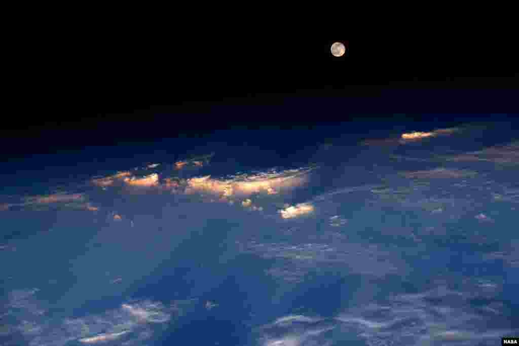 Komandan Expedition 48 Jeff Williams dari NASA mengambil foto ini dari Stasiun Antariksa Internasional. Ia menulis "Bulan purnama muncul tepat sebelum matahari terbenam saat kami berada di atas China barat."