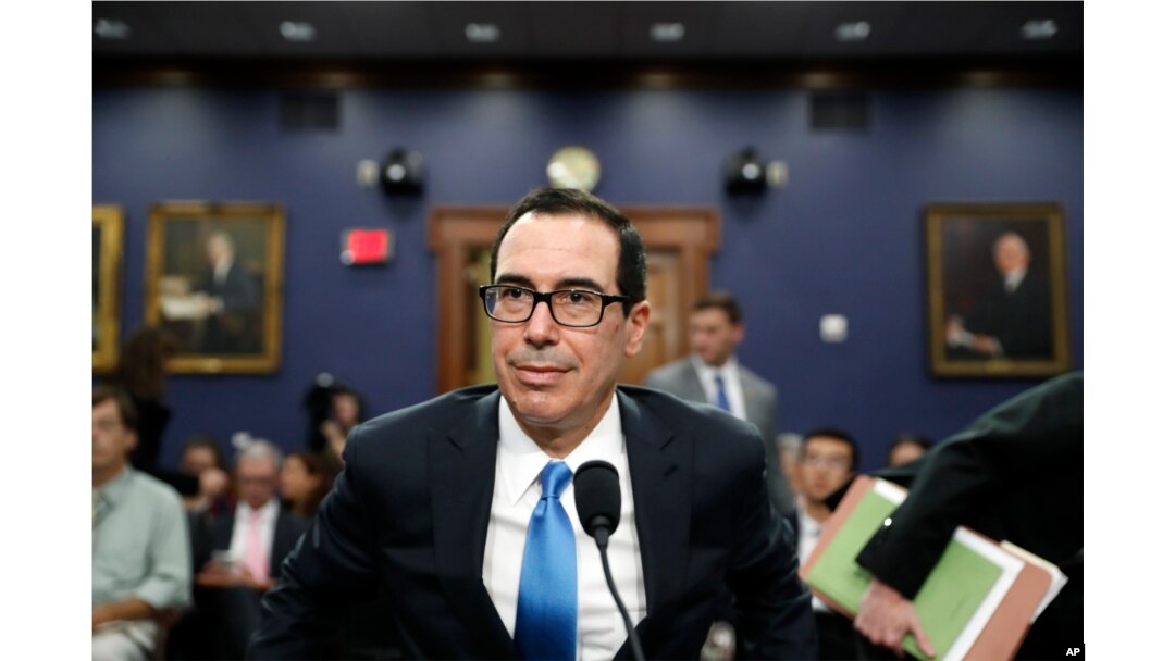 FILE - Treasury Secretary Steven Mnuchin takes his seat to testify at a House Appropriations subcommittee hearing on the budget on Capitol Hill, June 12, 2017.