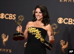 FILE - Julia Louis-Dreyfus poses in the press room with her awards for outstanding lead actress in a comedy series and outstanding comedy series for "Veep" at the 69th Primetime Emmy Awards at the Microsoft Theater in Los Angeles, Sept. 17, 2017.