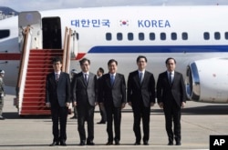 South Korea's national security director Chung Eui-yong, center, National Intelligence Service Chief Suh Hoon, second left, and other delegators pose before boarding an aircraft as they leave for Pyongyang at a military airport