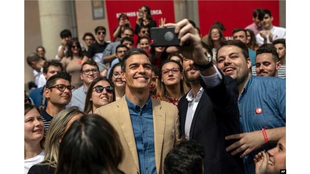 Spanish Prime Minister and Socialist Party candidate Pedro Sanchez, center, smiles for a photo during an election campaign event in Toledo, central Spain, April 26, 2019. What undecided voters do in this tight race will shape the fortunes of the two political blocs that loosely took shape during campaigning that ended Friday.