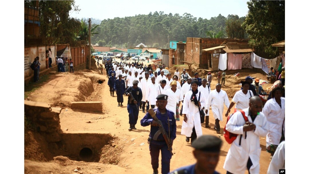 FILE - Doctors and health workers march in the Eastern Congo town of Butembo on April 24, 2019, after attackers shot and killed an epidemiologist from Cameroon who was working for the World Health Organization. Doctors at the epicenter of Congo's Ebola crisis have threatened to go on strike indefinitely if health workers are attacked again.
