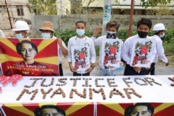 People hold a banner showing the portrait of Aung San Suu Kyi, in Mandalay, Myanmar February 19, 2021 in this picture obtained by REUTERS.