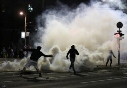 Demonstranti bacaju patrone sa suzavcem nazad ka snagama policije, tokom sukoba ispred Doma Narodne Skupštine Srbije, u centru Beograda, 7. jula 2020. (Foto: Rojters, Marko Đurica)