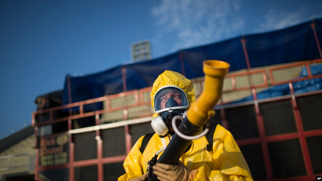 A health worker stands in the Sambadrome as he sprays insecticide to combat the Aedes aegypti mosquitoes that transmit the Zika virus, in Rio de Janeiro, Brazil, Tuesday, Jan. 26, 2016.