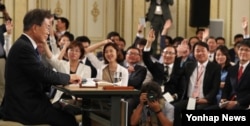 17일 문재인(왼쪽) 대통령 취임 100일 회견에 참석한 기자들이 질문하기 위해 손을 들고 있다.