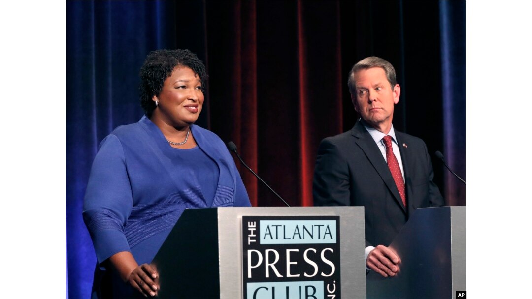 FILE - In this Tuesday, Oct. 23, 2018 file photo, Democratic gubernatorial candidate for Georgia Stacey Abrams, left, speaks as her Republican opponent Secretary of State Brian Kemp looks on during a debate in Atlanta.